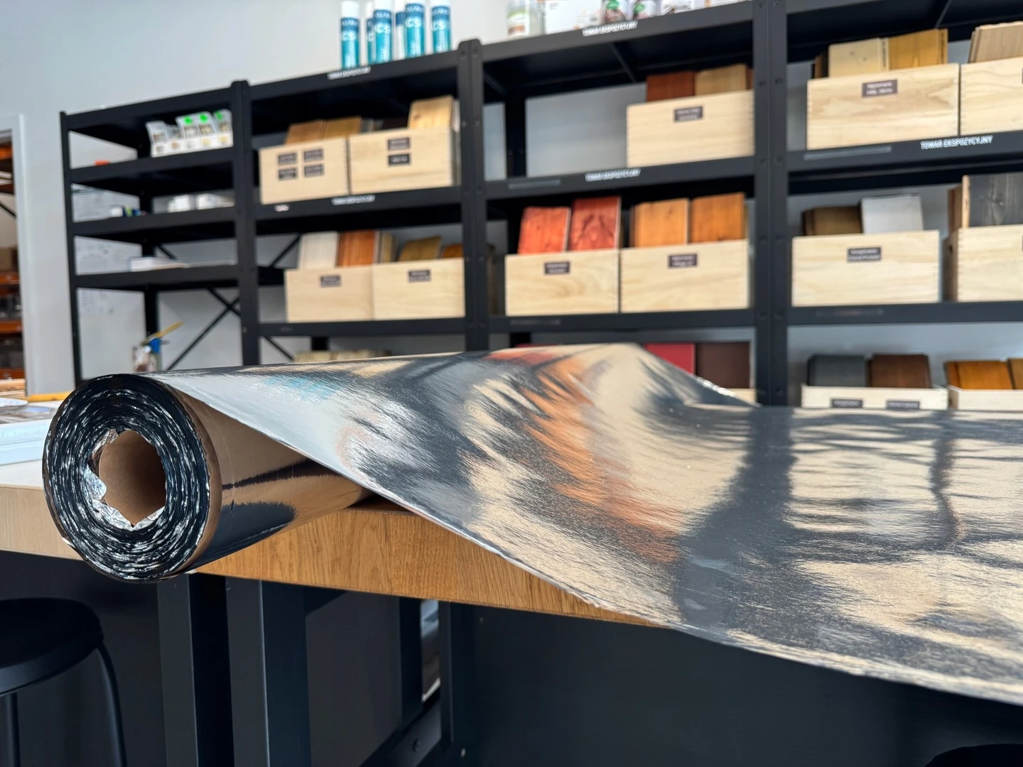 Tektura budowlana z folią aluminiową – rolka ochronna na stole w pracowni, do zabezpieczania podłóg i ścian podczas remontu